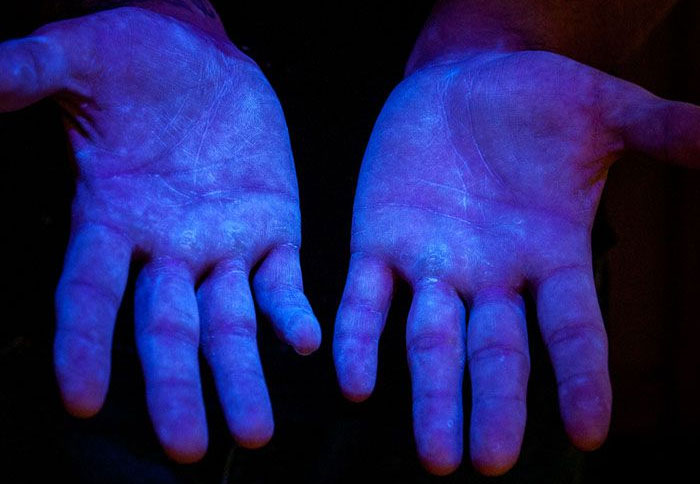 图6.紫外线下的荧光材料，以显示人手的覆盖范围。 来源www.glogerm.com